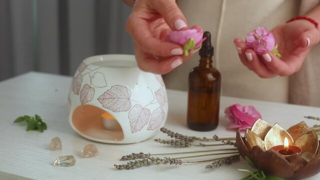 Woman prepares an aroma lamp and oils