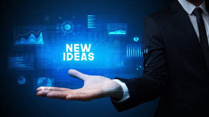 Hand of Businessman holding NEW IDEAS inscription, business success concept