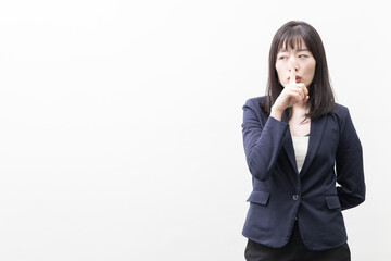 Woman raises her index finger in front of her mouth (gesture)