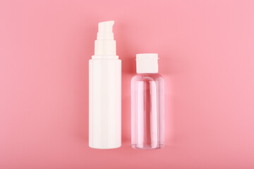 Set of cosmetic bottles for face cream or lotion and skin lotion or gel against pink background. Concept of skin care and beauty