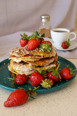 homemade pancakes with strawberries and honey on the table