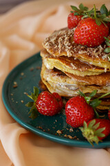 homemade pancakes with strawberries and honey on the table