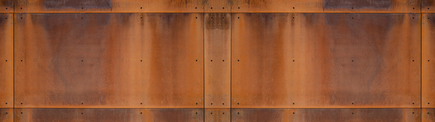 Grunge rusty corten steel facade wall with rivets, rust metal texture background banner panorama