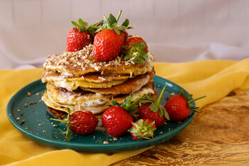 homemade pancakes with strawberries and honey on the table