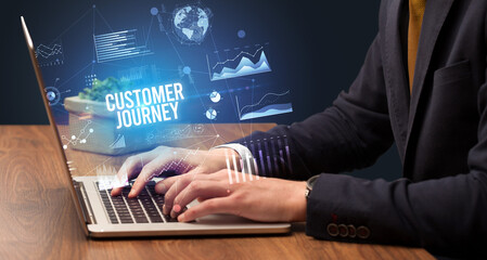 Businessman working on laptop with CUSTOMER JOURNEY inscription, new business concept