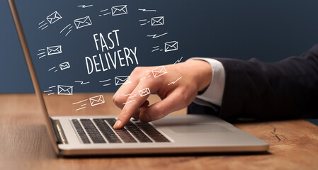 Businessman working on laptop with FAST DELIVERY inscription, online shopping concept