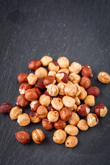 fresh natural hazelnuts on a dark stone background