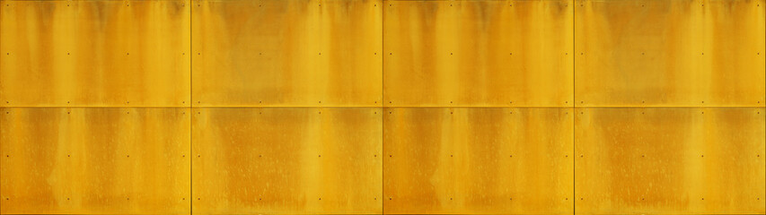Abstract yellow orange golden colored corten steel facade wall with rivets, painted metal texture background banner panorama
