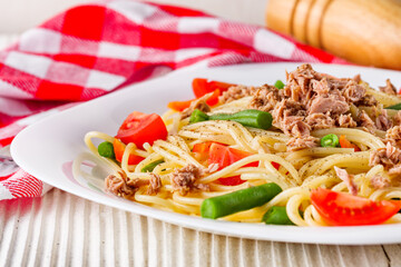 delicious traditional Italian pasta with tuna on a white rustic wooden background