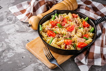 delicious traditional Italian pasta with tuna on a dark rustic stone background