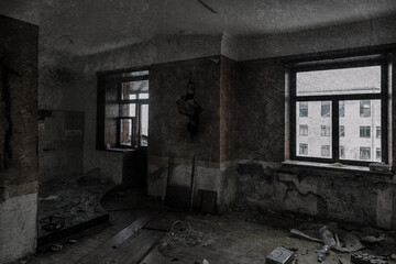An old dark room in an abandoned house. Scary room with windows. Dirty ragged walls. Old windows.