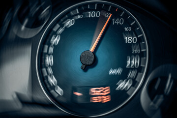 The speedometer of a modern car shows a high driving speed. Added motion blur.