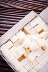 sugar refined on a dark rustic wooden background