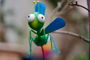 Green metal grasshopper on white background, Zurich, Switzerland.