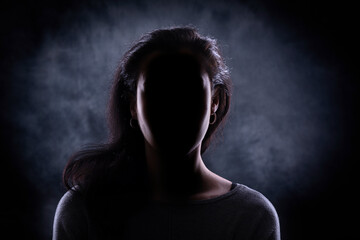 Female silhouette against a dark black background.