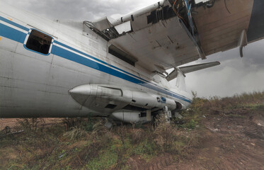 An abandoned old Soviet cargo plane lying on the ground in cloudy weather