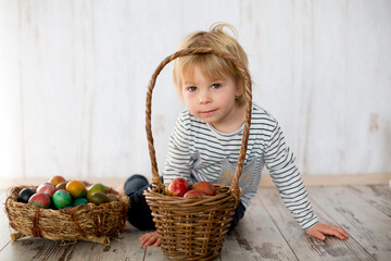 Sweet toddler child, cute boy playing with colorful easter eggs