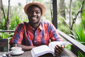 Fototapeta premium African man reading a book in coffee shop.World book day Concept