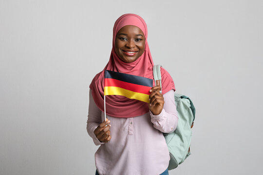 Pretty muslim lady student holding German flag