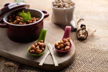 Vegan grilled chickpeas. Homemade vegan chickpeas, Crispy roasted organic chickpeas . Served as a snack in a bowl, on a wooden table top.