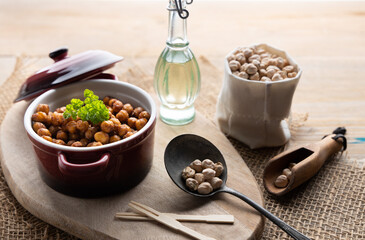 Vegan grilled chickpeas. Homemade vegan chickpeas, Crispy roasted organic chickpeas . Served as a snack in a bowl, on a wooden table top.