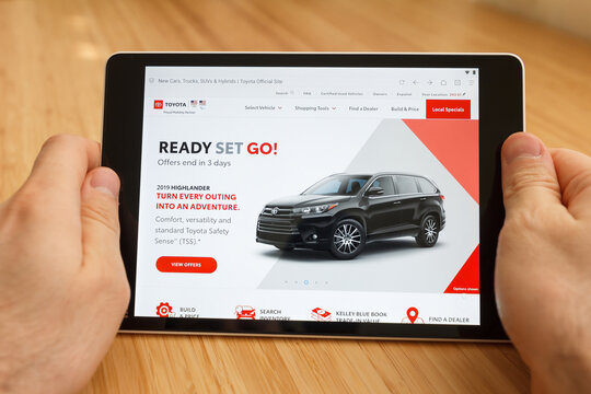 SAN FRANCISCO, US - 1 April 2019: Close up to hands holding tablet using internet and looking through Toyota web site, in San Francisco, California, USA. An illustrative editorial image.
