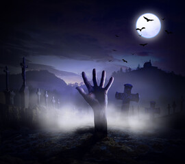 Halloween creepy and ghostly horror scary full moon night with hand out of grave tombstone and...