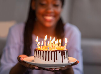 Beautiful birthday cake with candles in black woman hands