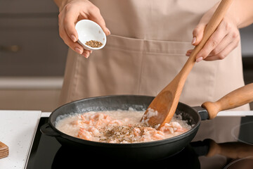Woman cooking risotto in kitchen