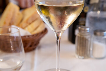 Close-up of a glass of white wine on a served table in a restaurant. Selective focus. Food catering concept