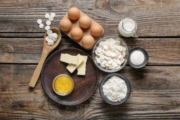 Chocolate drops and ingredients for bakery on wooden background