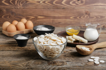 Chocolate drops and ingredients for bakery on wooden background