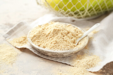 Plate with banana flour on light background