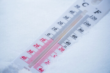 The thermometer lies on the snow in winter showing a negative temperature. Meteorological...