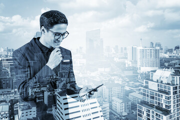 Young handsome businessman in suit and glasses using phone and thinking how to tackle the problem, new career opportunities, MBA. Bangkok on background. Double exposure.