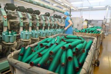 Obraz premium Close-up of the produced threads against the background of the production line. Factory for the production of threads and fabrics