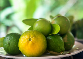 Fresh green eco Lime fruits with green leaf on the plate.