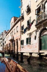 Typische Szene in Venedig. Blick auf einen Kanal, gesäumt vom alten Gebäuden, mit Brücken und Gondeln