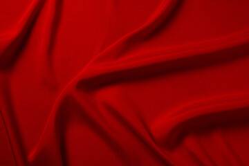 Red silk or satin luxury fabric texture can use as abstract background. Top view.