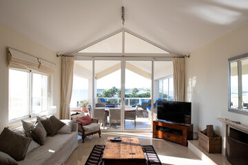 Obraz premium Large living room big full length glass doors leading onto an outside terrace