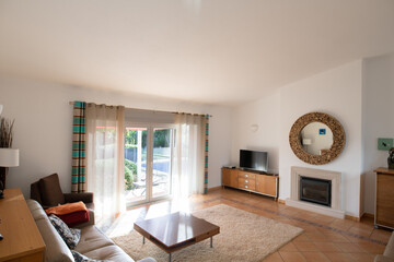 Living room with tiled floors, patio doors and high sloping ceiling