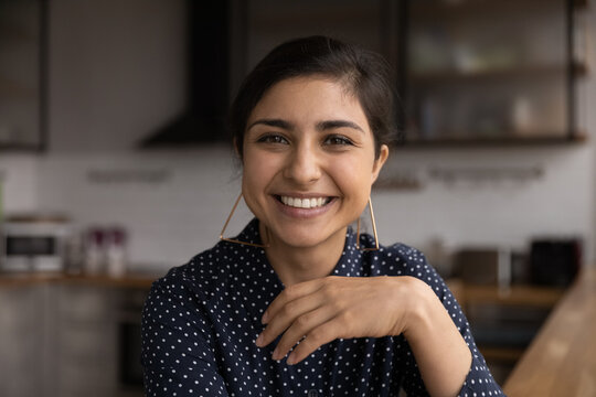 Head shot portrait close up smiling Indian woman young making video call, chatting online, looking at camera, posing for profile picture, mentor coach shooting webinar, influencer recording vlog