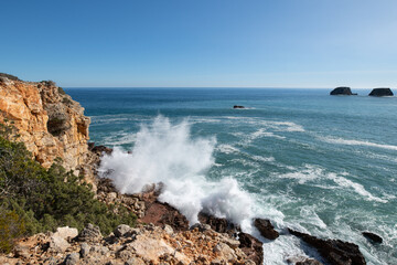 Waves crashing onto rocks on the Algarve Coastline