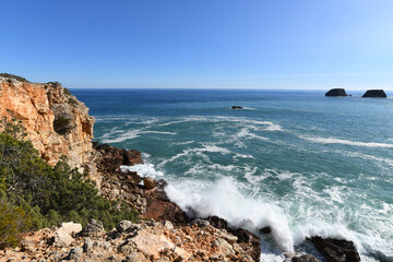 Waves hitting the base of the cliffs on the western Algarve in Portugal