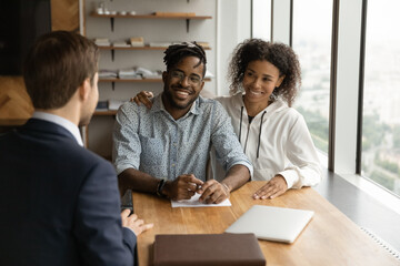 Close up happy smiling African American young couple listening to manager financial advisor realtor...