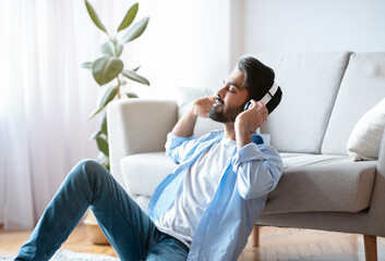Young Arab Guy In Wireless Headphones Enjoying Listening Music At Home