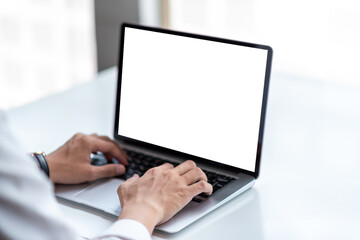 Mock up. Man using laptop white blank screen table at office.