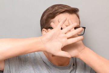Shot of mature man raising hands and covering his face