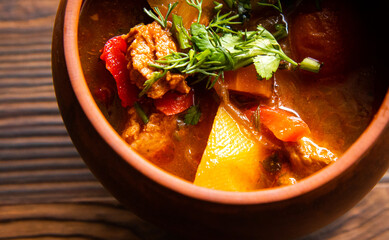 Georgian soup kharcho. Close-up. Soup in a clay pot on a wooden background