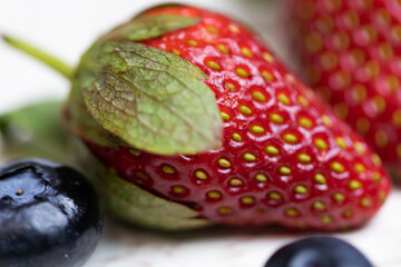Ripe and juicy strawberries and blueberries on a white background. Healthy eating.